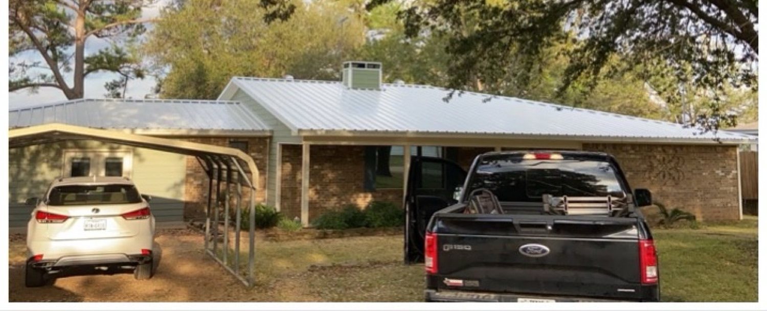 Light standing seam metal on a brick ranch near the lake