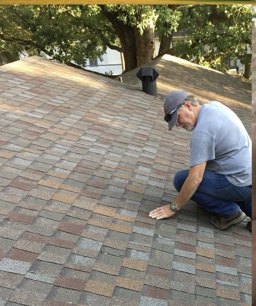 Robbie Reece inspecting shingles after a storm