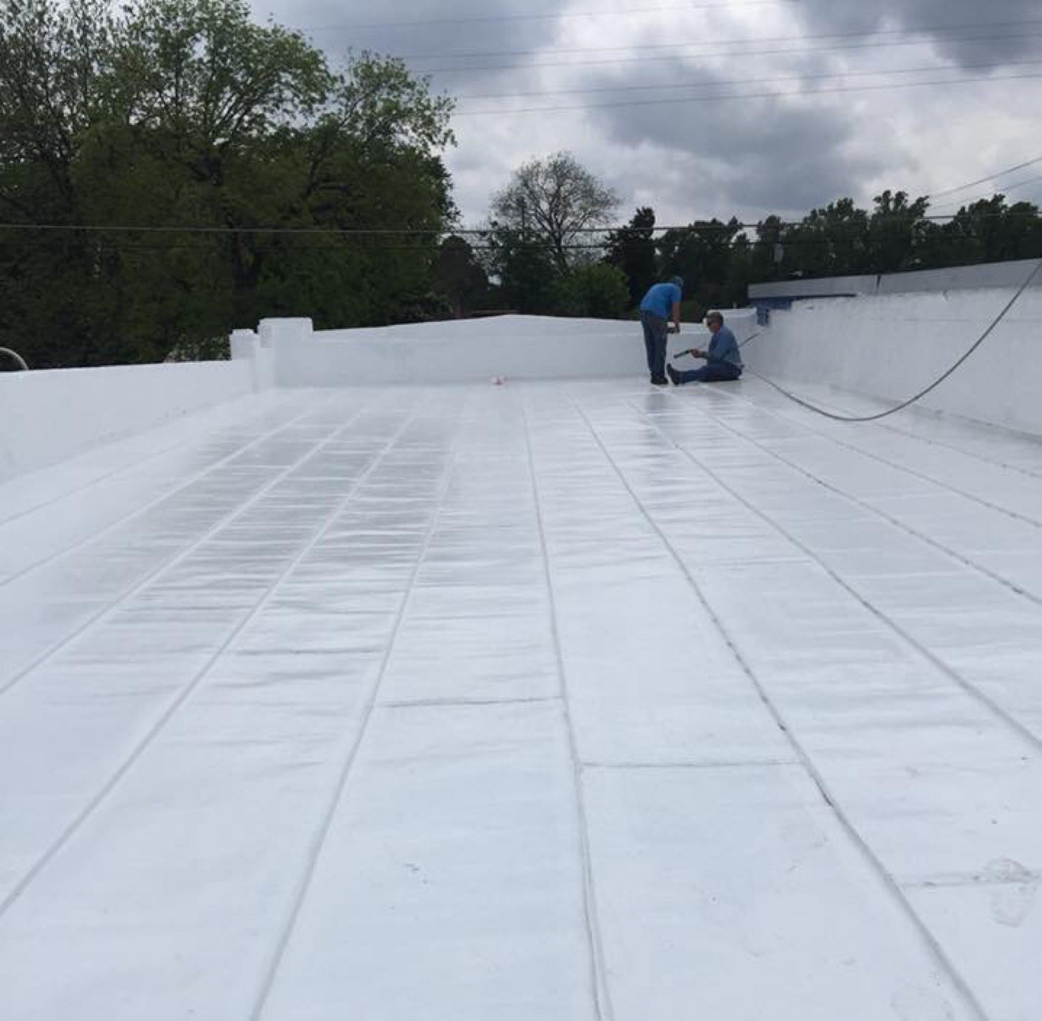 Crew finishing a white commercial membrane roof